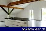 grozgiger Wohn-/Essbereich mit offener EBK und Zugang zum Balkon