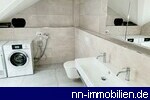 Modernes Tageslichtbad mit Doppelwaschbecken, WC sowie Waschmaschine und Tumbler.